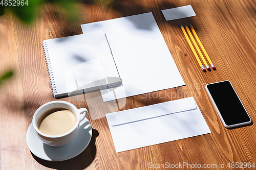 Image of Creative and cozy workplace at home office, inspirational mock up with plant shadows on table surface