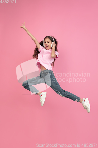 Image of Caucasian little girl portrait isolated on pink studio background, emotions concept