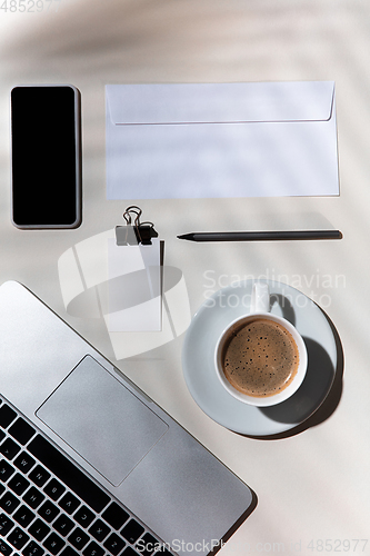 Image of Creative and cozy workplace at home office, inspirational mock up with plant shadows on table surface