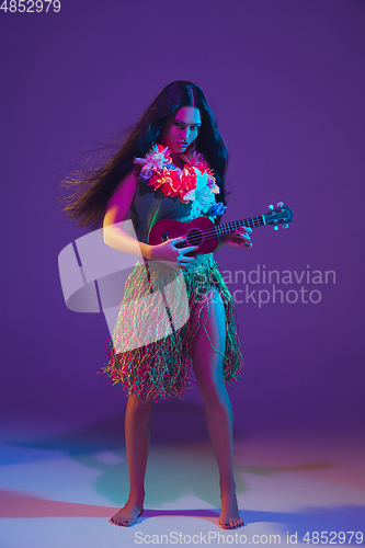 Image of Fabulous Cinco de Mayo female dancer on purple studio background in neon light