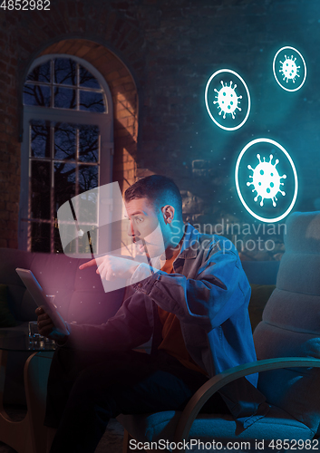 Image of Shocked, upset and sad man using gadgets to get information of coronavirus pandemic spread