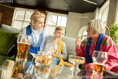 Image of Excited family watching football, sport match at home, grandma, mother and son