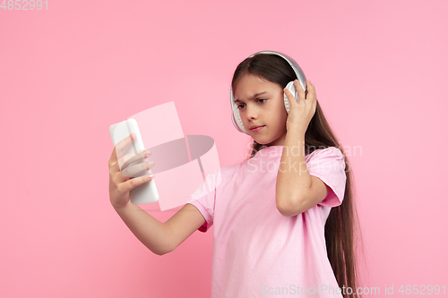 Image of Caucasian little girl portrait isolated on pink studio background, emotions concept
