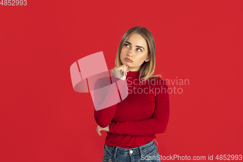 Image of Monochrome portrait of young caucasian blonde woman on red background