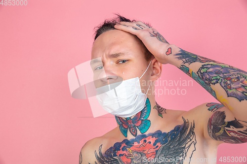 Image of Portrait of young man with freaky appearance on pink background