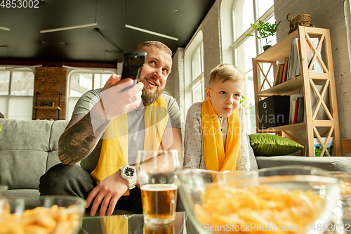 Image of Excited family watching football, sport match at home, father and son