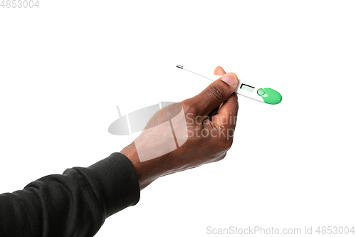 Image of How coronavirus changed our lives. Close up of male hands holding thermometer, taking temperature on white background