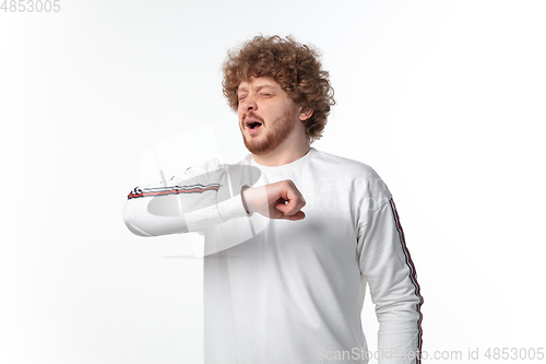 Image of How coronavirus changed our lives. Young man sneezing on white background