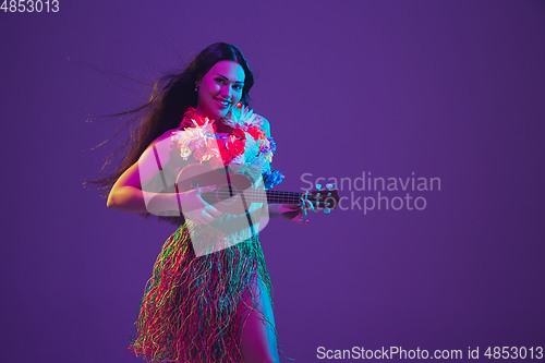 Image of Fabulous Cinco de Mayo female dancer on purple studio background in neon light