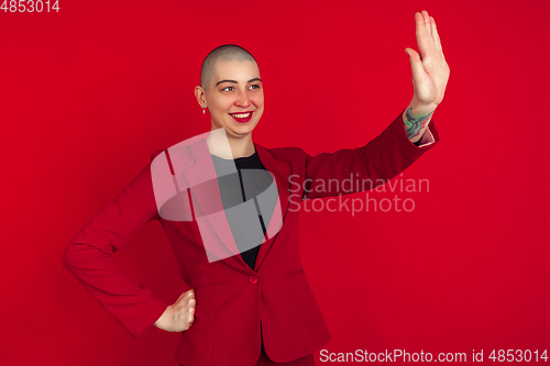 Image of Portrait of young caucasian bald woman on red background