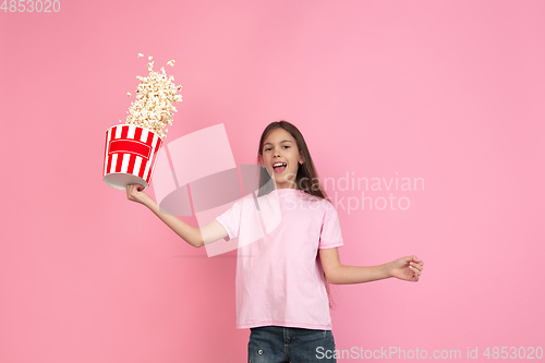 Image of Caucasian little girl portrait isolated on pink studio background, emotions concept