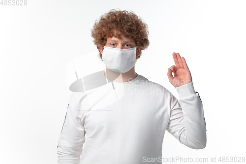 Image of How coronavirus changed our lives. Young man wearing face mask to stop spreading on white background