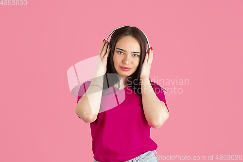 Image of Monochrome portrait of young caucasian brunette woman on pink background