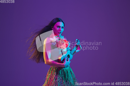 Image of Fabulous Cinco de Mayo female dancer on purple studio background in neon light