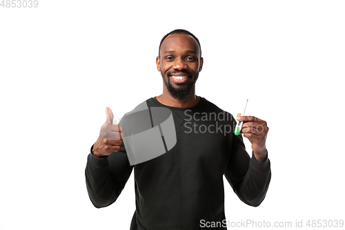 Image of How coronavirus changed our lives. Young man checking, taking temperature on white background