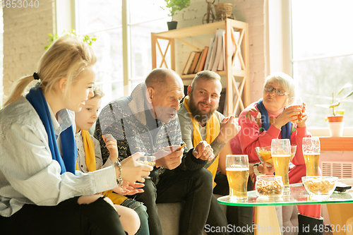 Image of Excited family watching football, sport match at home
