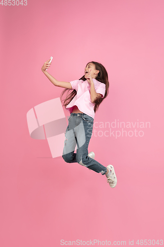 Image of Caucasian little girl portrait isolated on pink studio background, emotions concept