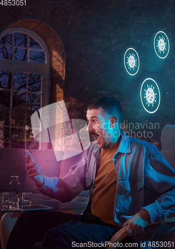 Image of Shocked, upset and sad man using gadgets to get information of coronavirus pandemic spread