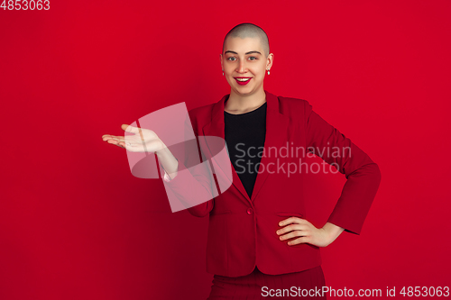 Image of Portrait of young caucasian bald woman on red background