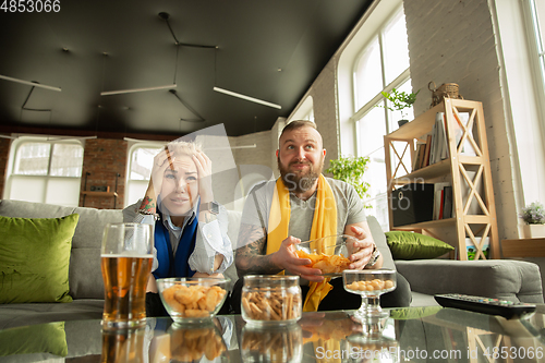 Image of Excited family watching football, sport match at home, beautiful couple