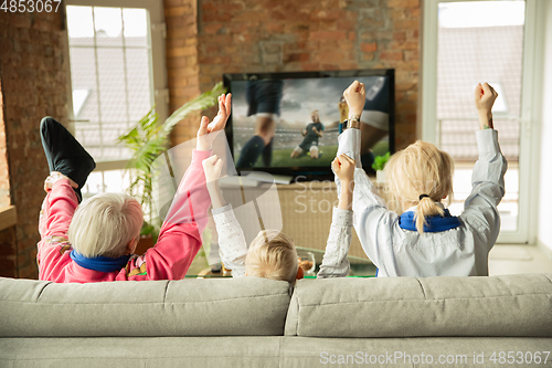 Image of Excited family watching football, sport match at home, grandma, mother and son