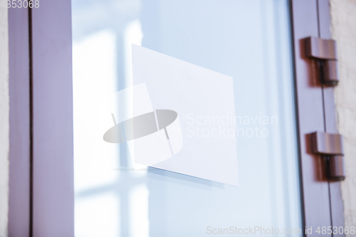 Image of Coronavirus Pandemic. A disinfector in a protective suit and mask leaves a warning sign on the door, copyspace