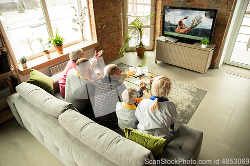 Image of Excited family watching football, sport match at home