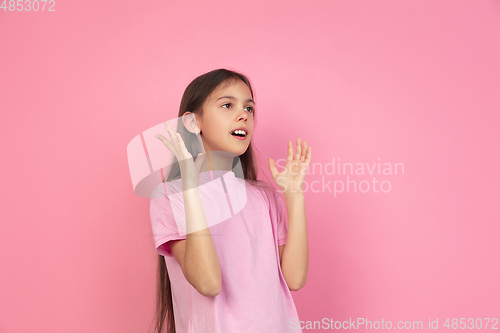 Image of Caucasian little girl portrait isolated on pink studio background, emotions concept