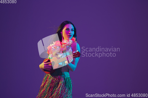 Image of Fabulous Cinco de Mayo female dancer on purple studio background in neon light