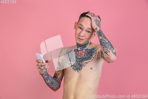 Image of Portrait of young man with freaky appearance on pink background