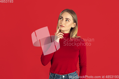Image of Monochrome portrait of young caucasian blonde woman on red background