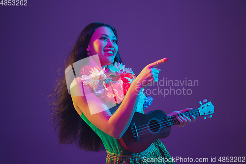 Image of Fabulous Cinco de Mayo female dancer on purple studio background in neon light