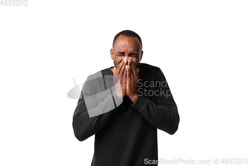 Image of How coronavirus changed our lives. Young man sneezing on white background