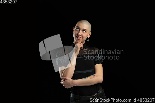 Image of Monochrome portrait of young caucasian bald woman on black background