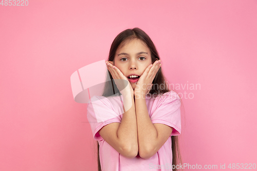 Image of Caucasian little girl portrait isolated on pink studio background, emotions concept