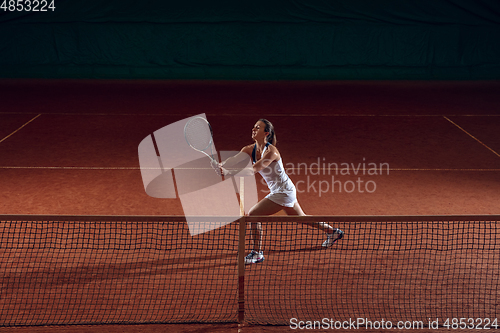 Image of Young caucasian professional sportswoman playing tennis on sport court background