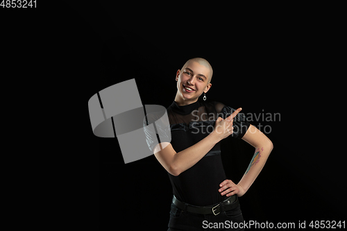 Image of Monochrome portrait of young caucasian bald woman on black background