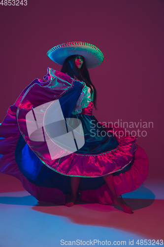 Image of Fabulous Cinco de Mayo female dancer on purple studio background in neon light