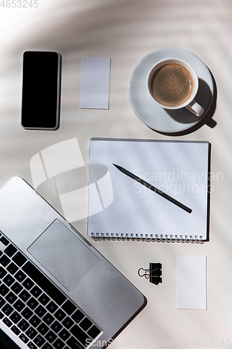 Image of Creative and cozy workplace at home office, inspirational mock up with plant shadows on table surface