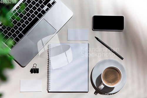 Image of Creative and cozy workplace at home office, inspirational mock up with plant shadows on table surface