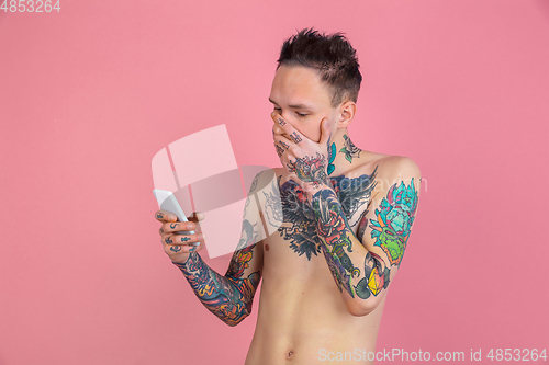 Image of Portrait of young man with freaky appearance on pink background