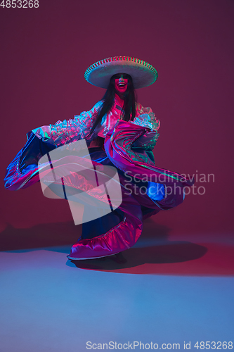 Image of Fabulous Cinco de Mayo female dancer on purple studio background in neon light