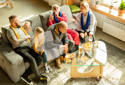 Image of Excited family watching football, sport match at home, top view