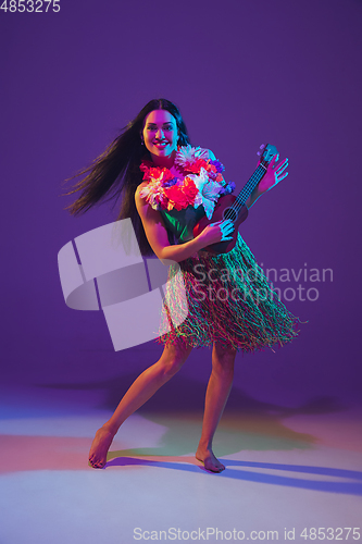 Image of Fabulous Cinco de Mayo female dancer on purple studio background in neon light