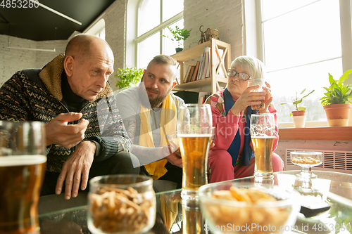 Image of Excited family watching football, sport match at home