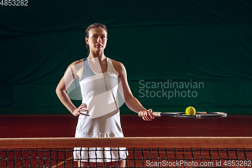 Image of Young caucasian professional sportswoman playing tennis on sport court background