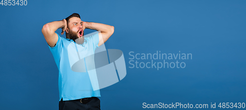 Image of Caucasian man\'s portrait isolated on blue studio background with copyspace