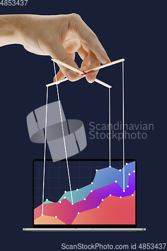 Image of Businessman keeping the growth in economy, manipulating graphs like puppet