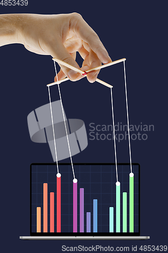 Image of Businessman keeping the growth in economy, manipulating graphs like puppet