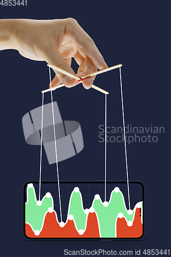 Image of Businessman keeping the growth in economy, manipulating graphs like puppet